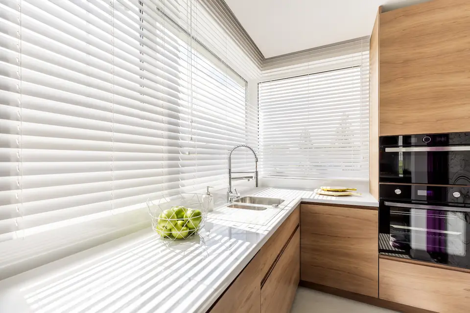 Sheer shadings with soft fabric vanes filtering daylight in a kitchen